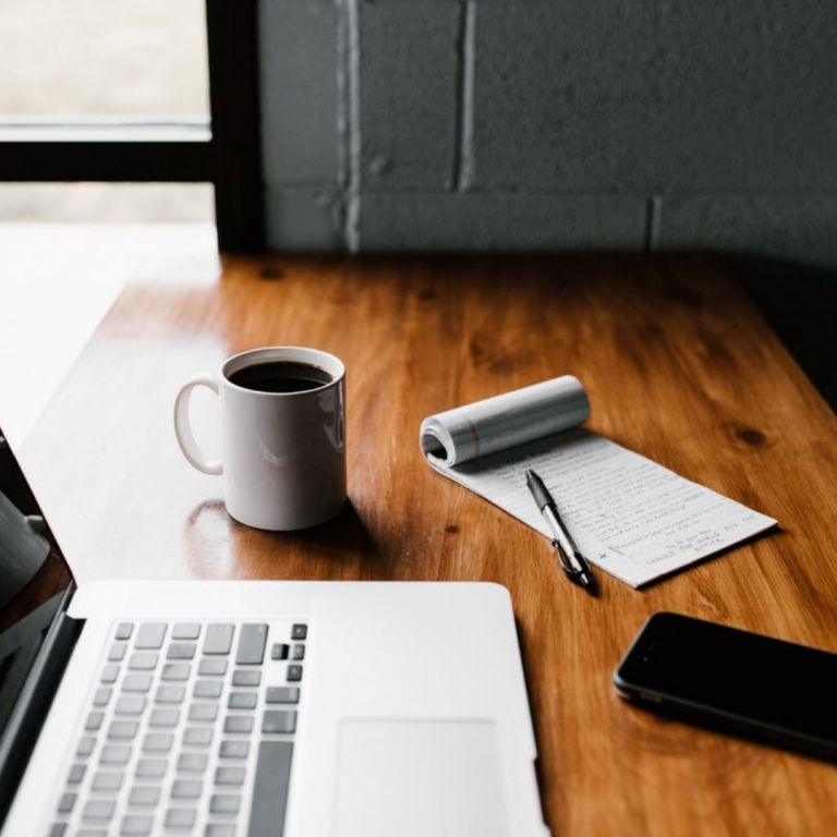 a laptop and a cup of coffee on a table