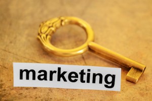 Gold key on a flat surface with the word marketing