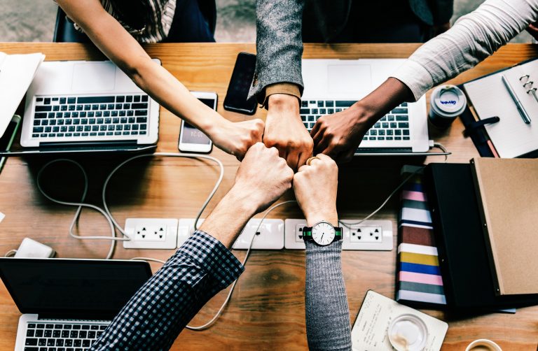 a group of people putting their fists together