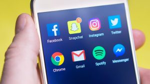 hand holding a phone with social icons and communication icons hand holding a phone with social icons and communication icons
