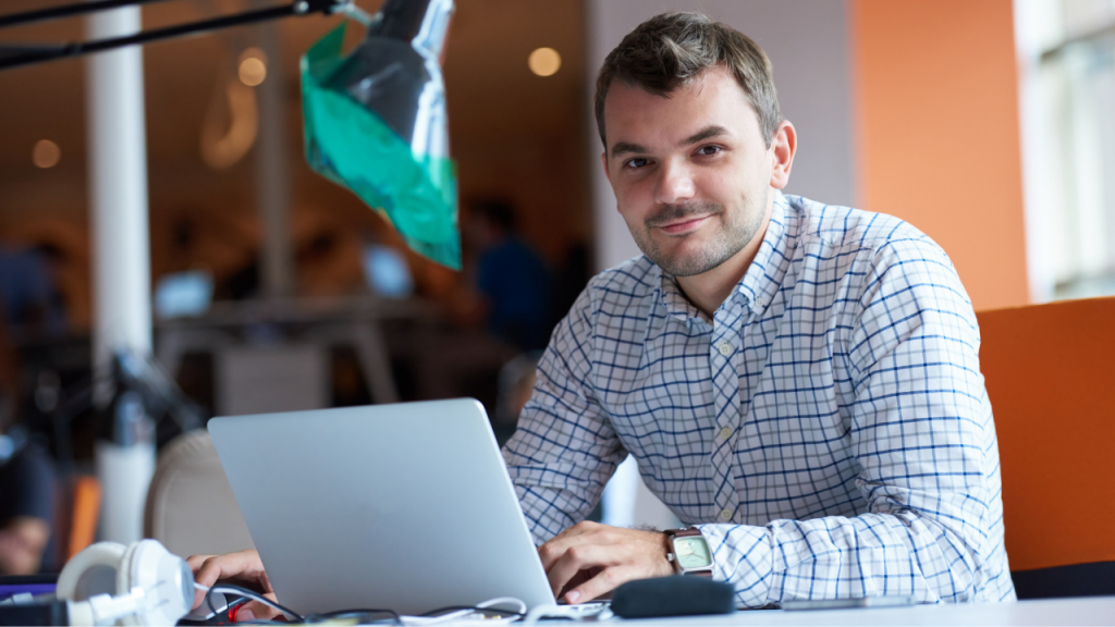 Man sat a desk with a laptop