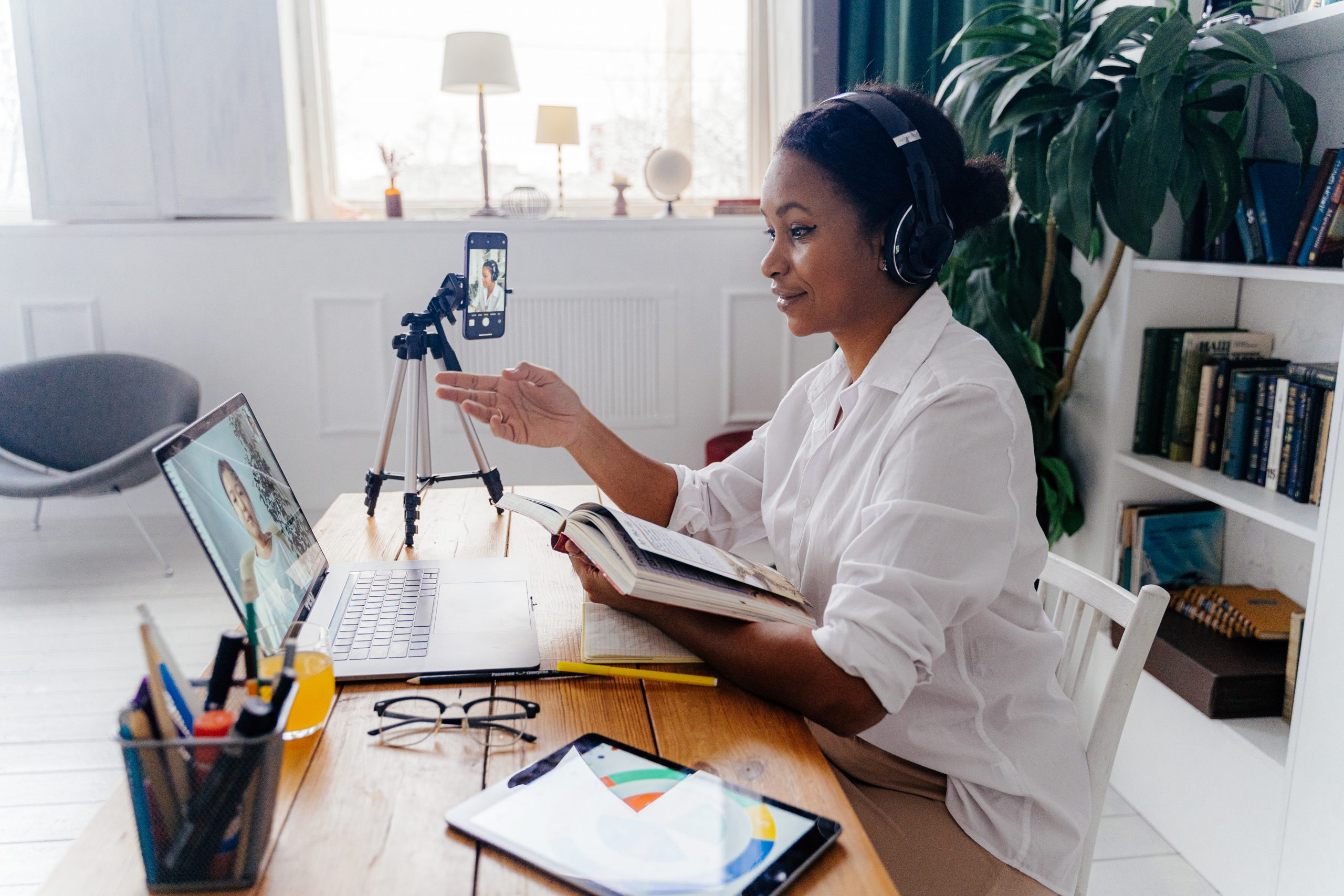 Colored lady sat at a desk with earphones on having an online meeting Colored lady sat at a desk with earphones on having an online meeting