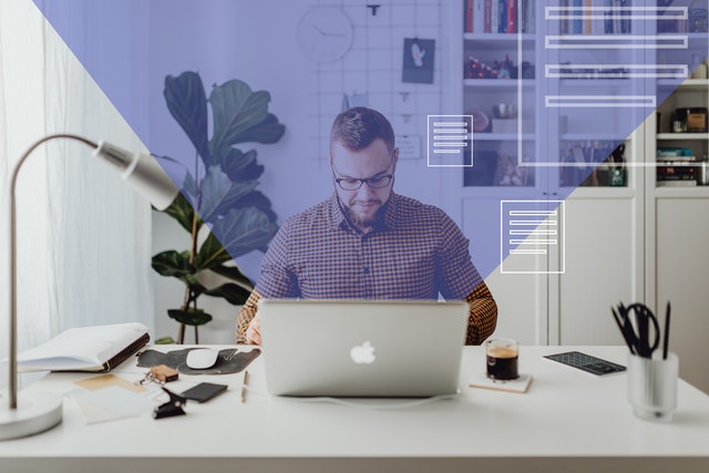 a man sitting at a desk with a laptop