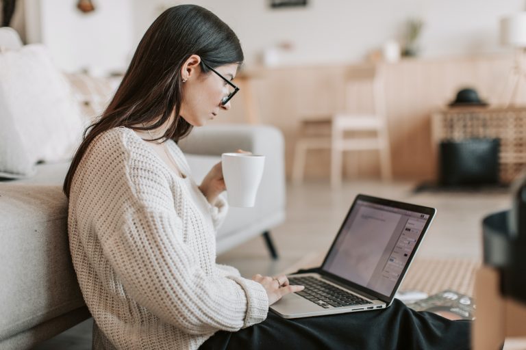 a woman sitting on the floor using a laptop