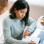 Home New 7 a woman writing in a notebook