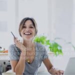 Home New 6 a woman smiling at a laptop