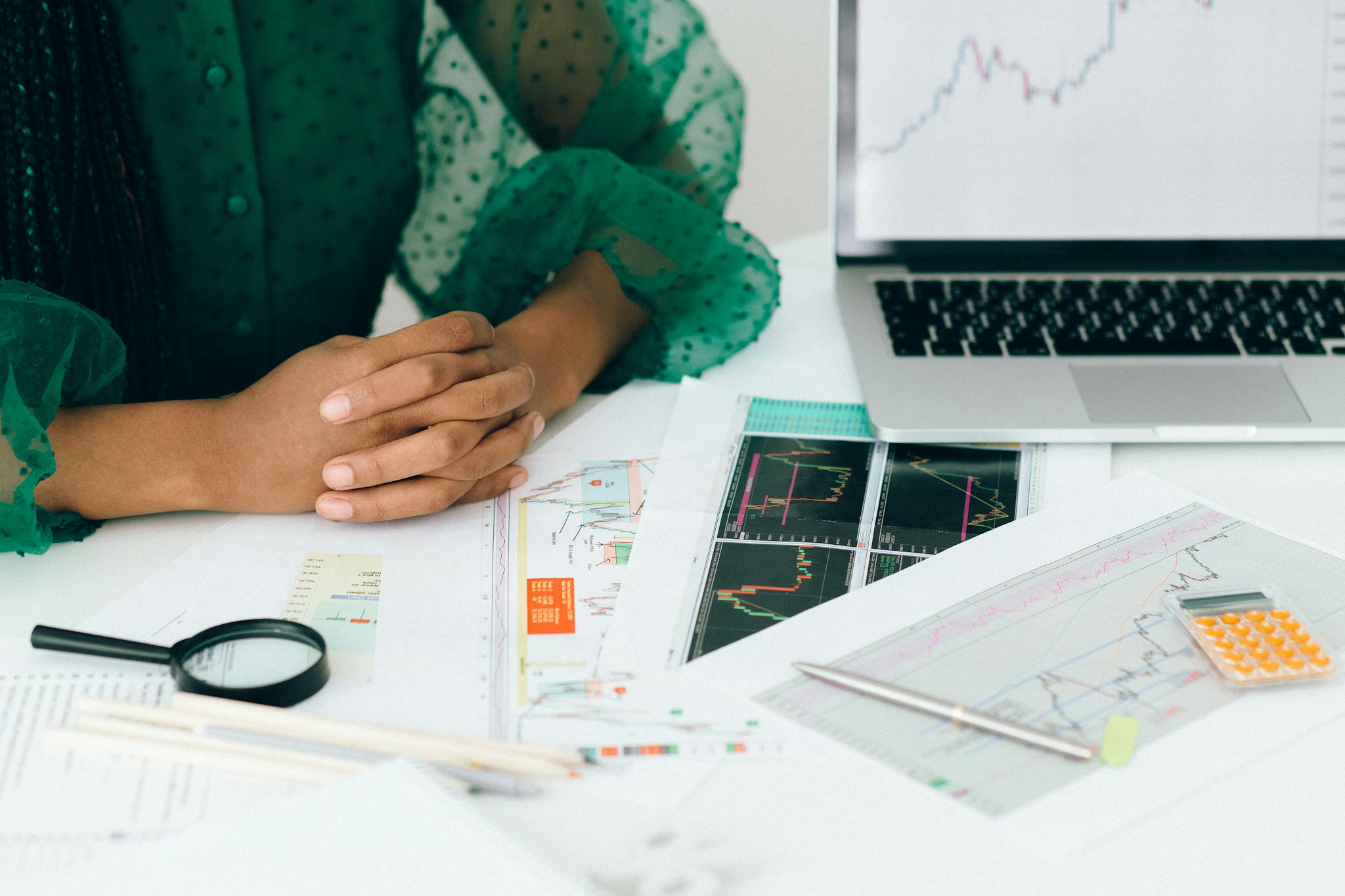 Fuji Line 2 A person analyzes financial charts and graphs at a desk, indicating business trading activity.